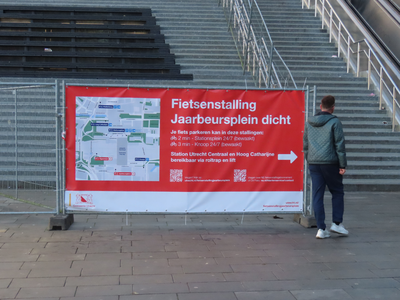 912199 Afbeelding van een grote banner bij de trappen op het Jaarbeursplein te Utrecht, met de mededeling dat de ...